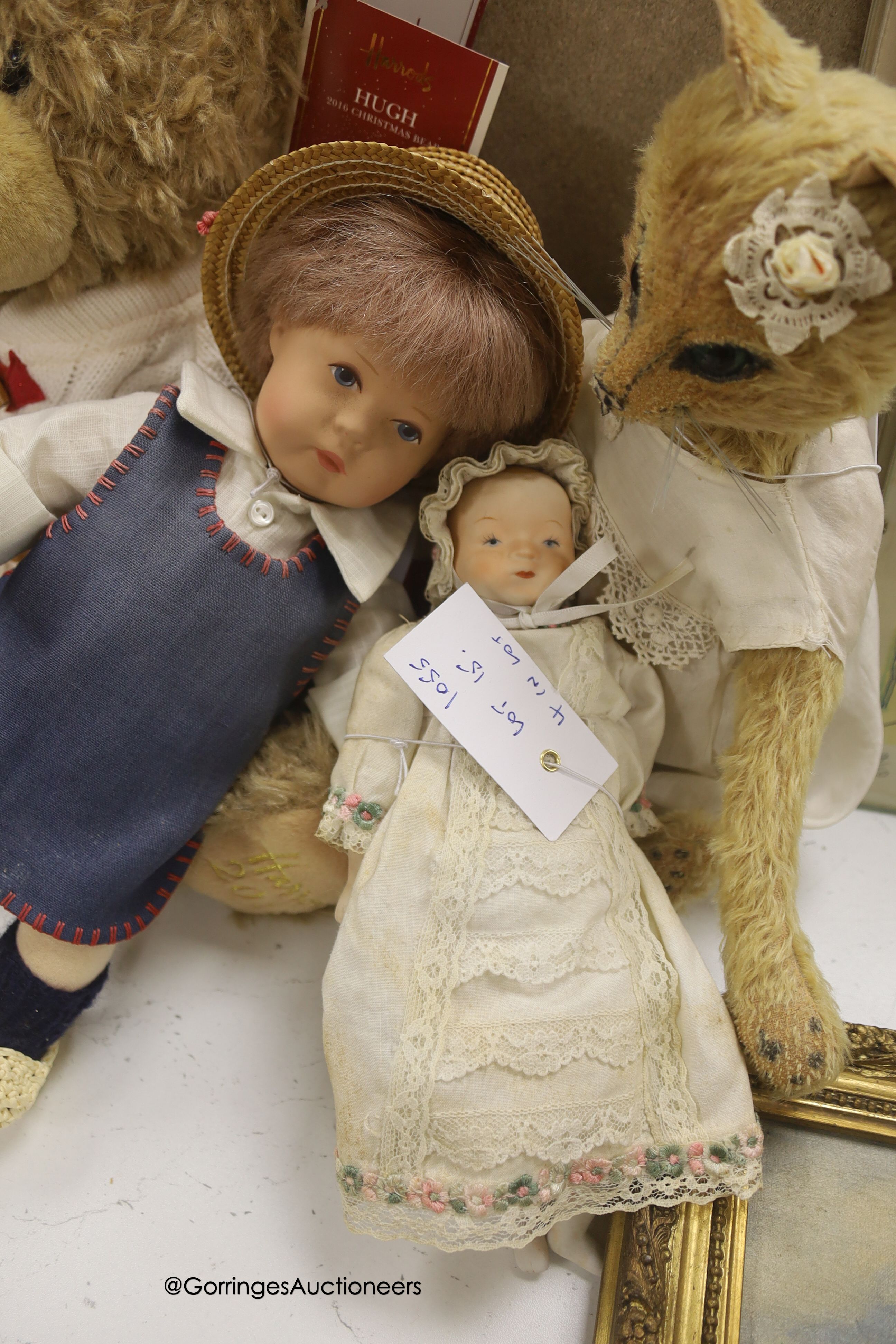 A modern Kathe Kruse doll with Burlington Berties cot and modern china baby doll and Harrods bear